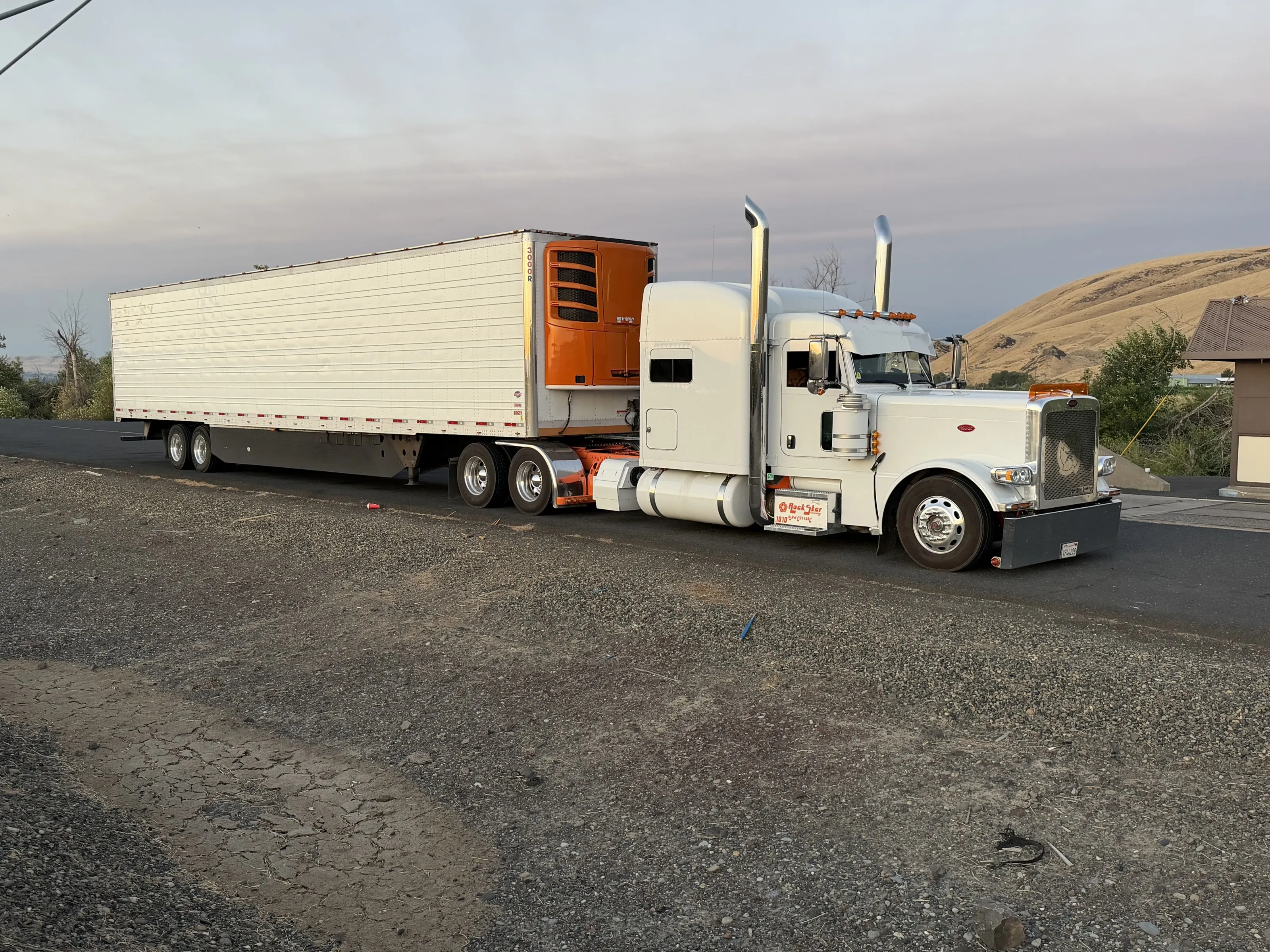 Rockstar Trucking rig with refrigerated trailer parked at dusk